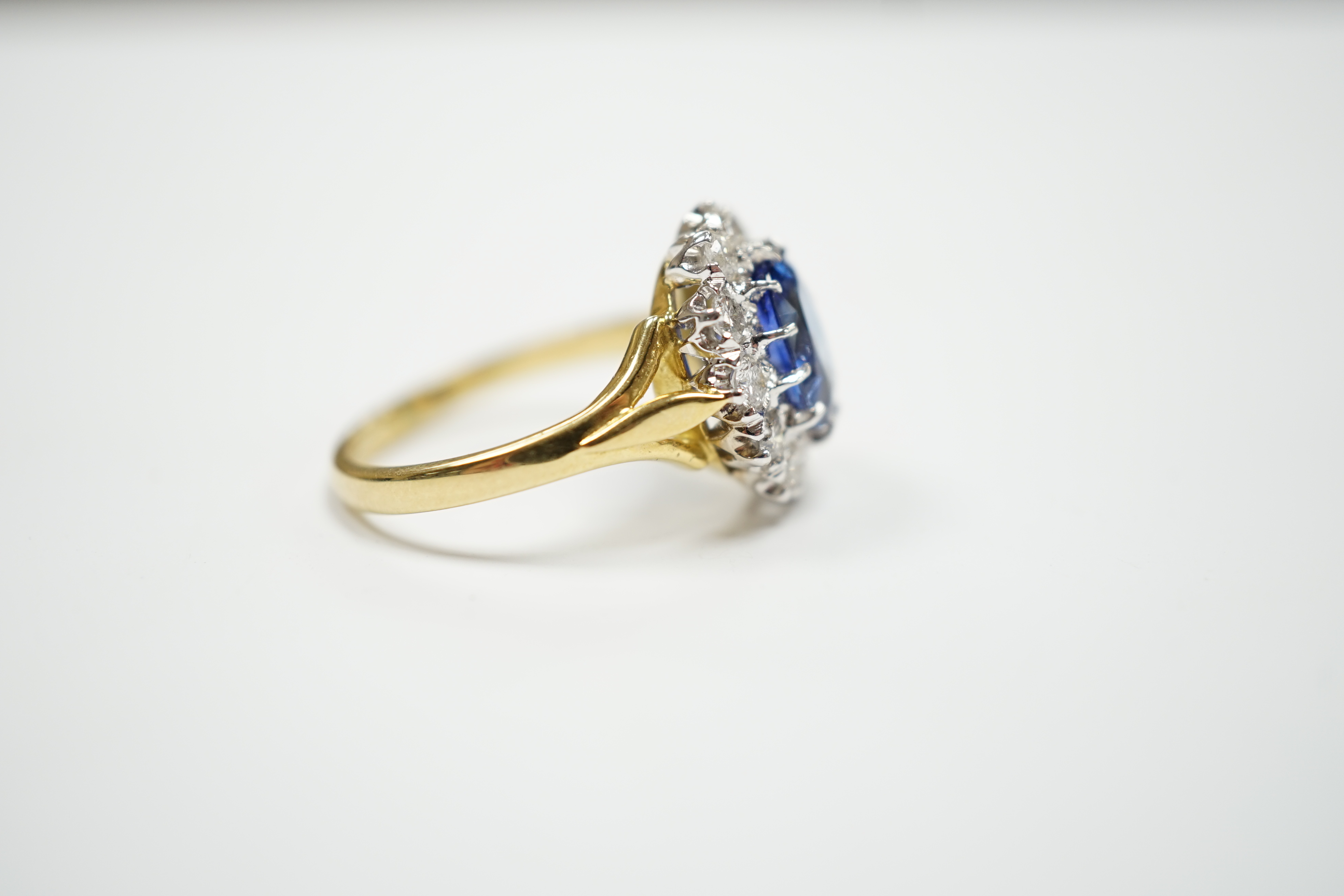 A modern 18ct gold, sapphire and diamond set oval cluster ring, size O, gross weight 5.6 grams.
